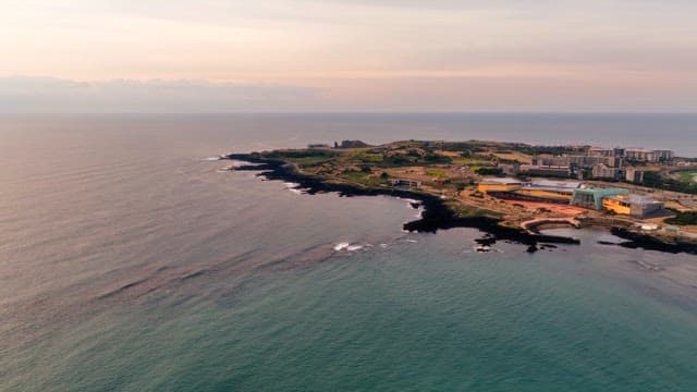 Coastal landscape with buildings at sunset