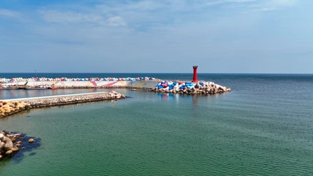 Calm sea with a red lighthouse