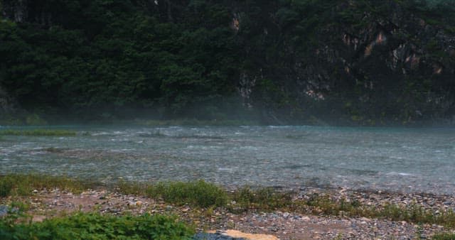Misty River Flowing Through A Forested Valley