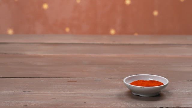 Hands serving a bowl of delicious black bean sauce with rice on a wooden table