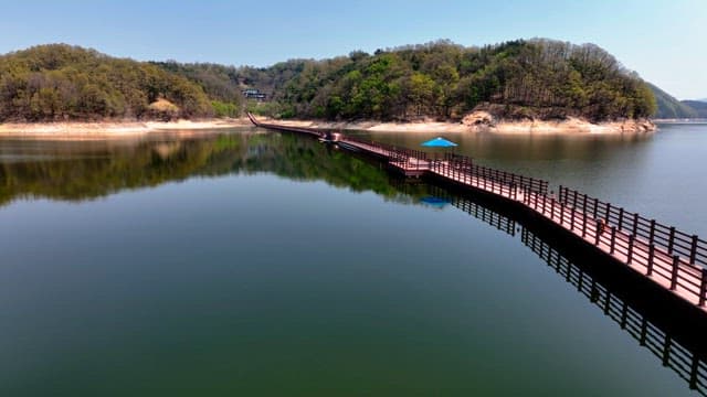 Serene lake with a long wooden walkway