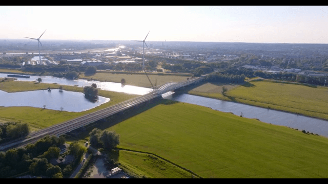 Scenic view of a river with wind turbines
