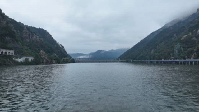 Cloudy Lake View with Passing Train and Mountains
