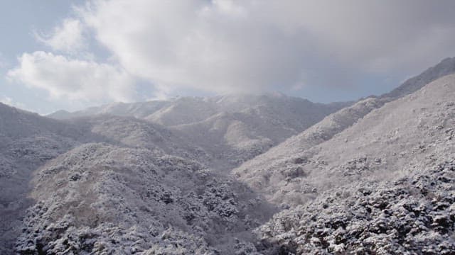 Snow-covered mountains under a cloudy sky