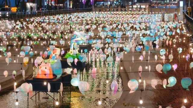 People enjoying the colorful lanterns that light up cheonggyecheon stream