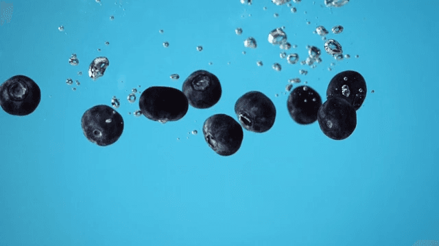 Blueberries underwater with bubbles rising