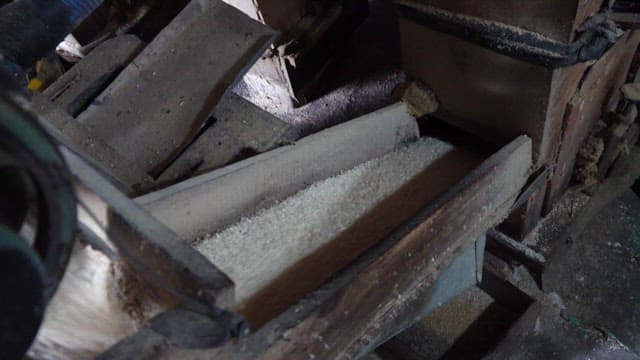 Rice being processed by a machine in a rice mill