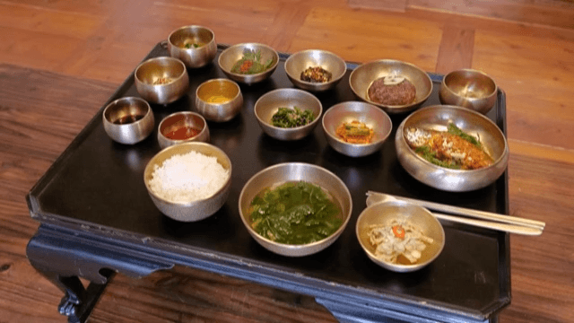 Traditional Wooden Table being Set with Korean Meal