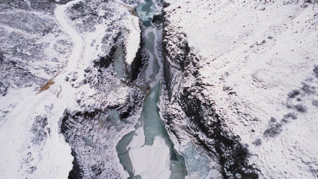 Snow-covered canyon with a frozen river
