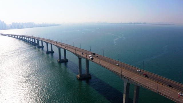 Incheon bridge over a calm sea with a city skyline
