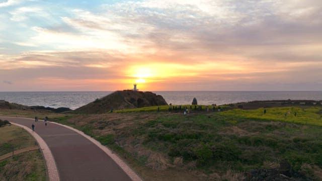 Sunset view with a lighthouse by the sea