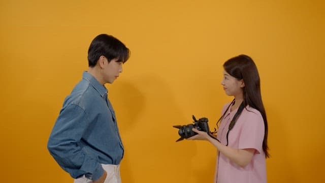 Female photographer taking pictures of male models with camera