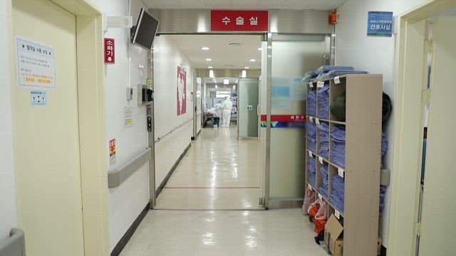 Hospital hallway with medical staff in protective gear