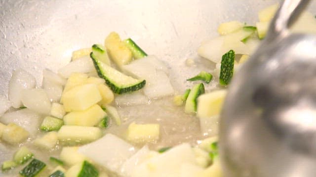 Chopped onions and zucchini fried in a pan