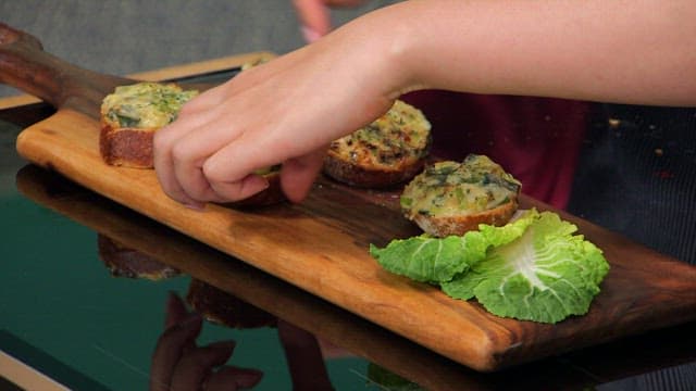 Preparing a crispy and appetizing baguette topped with green onions on a wooden cutting board