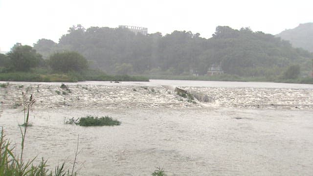 Swollen River Flowing under Rainfall