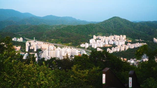 Aerial view of city buildings surrounded by forested hills