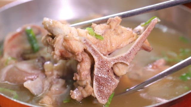 Chopstickful of Korean beef bone soup with tender meat