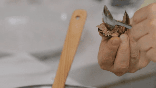 Putting rice between mussels with a spoon