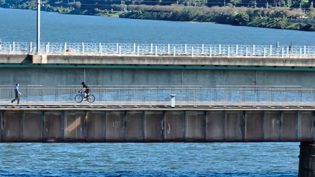 Cyclist and pedestrian on a bridge