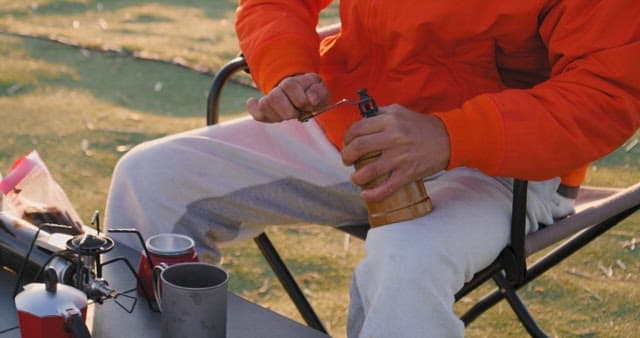 Preparing coffee outdoors with a manual grinder