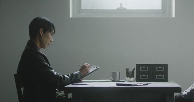 Man filling forms in a dimly lit room