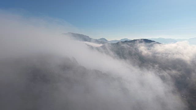 Misty mountains with clouds and blue sky
