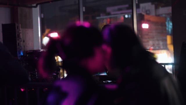 Two People Chatting While Watching a DJ