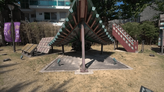 Traditional Korean roof structure displayed in an urban park