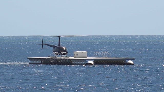 Helicopter taking off from a floating platform in the sea
