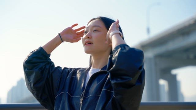 Woman adjusting her hair outdoors