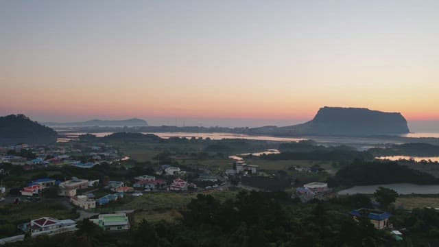 Sunset over a serene landscape with distant mountain