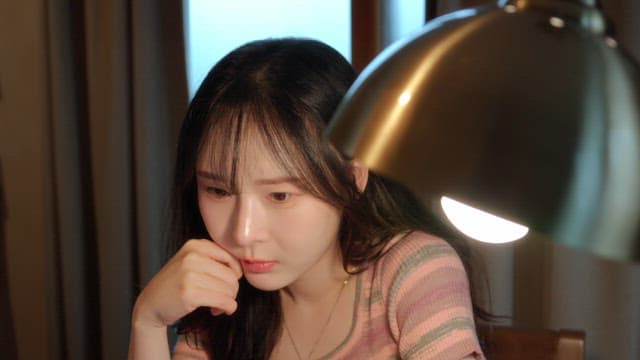 Woman thinking deeply at a desk