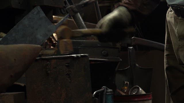 Blacksmith shaping metal with a hammer