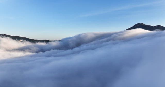 Clouds rolling over a mountain peak