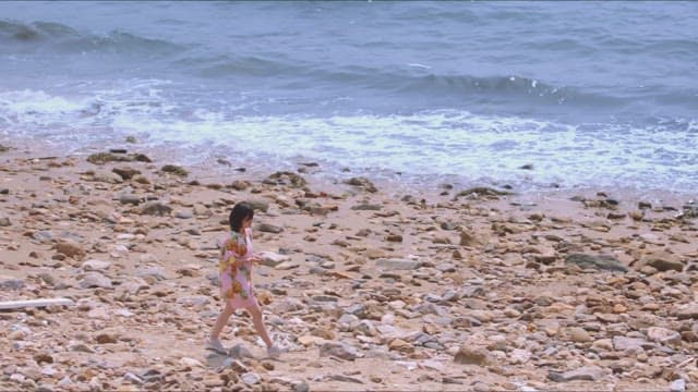 Woman collecting stones on a rocky beach