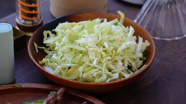 Chopped cabbage in a wooden bowl on a table