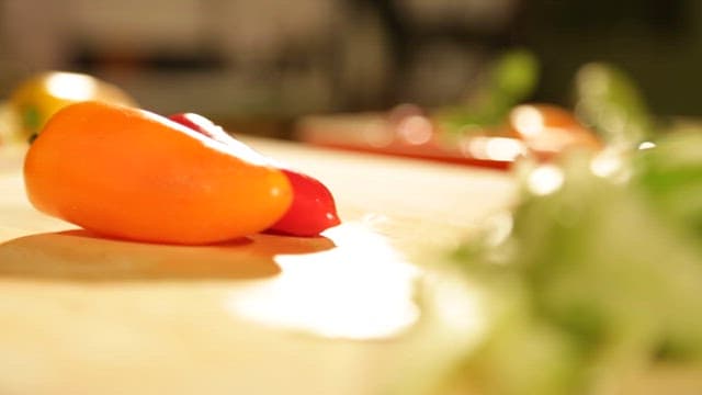 Cutting Colorful Bell Peppers on a Wooden Cutting Board