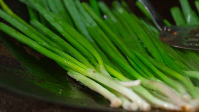 Green onions cooked in an oiled pan
