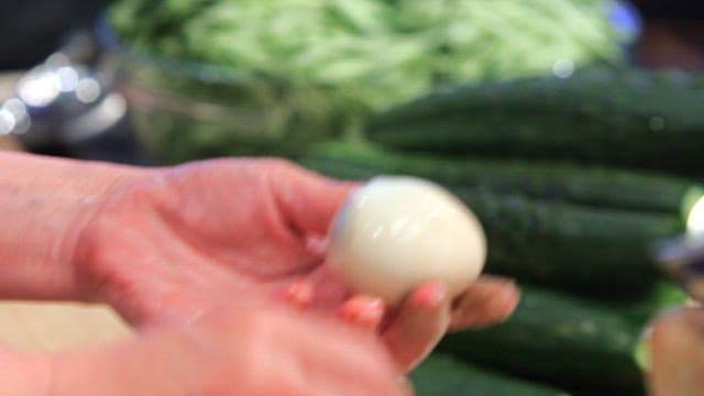 Peeling a boiled egg in the kitchen