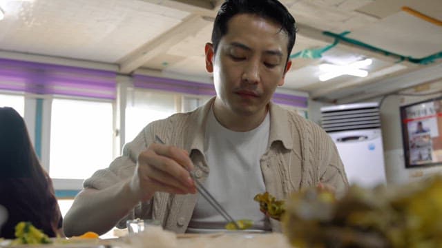 Man eating ssam at a restaurant