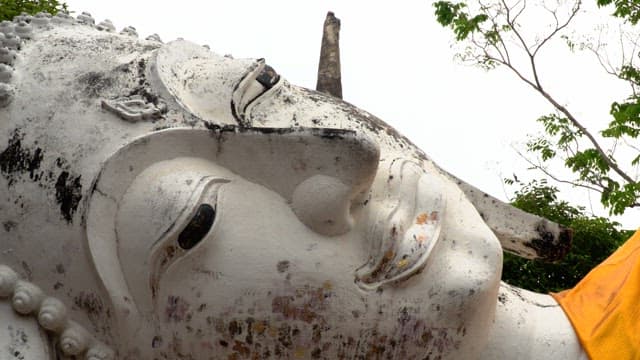 Face of reclining Buddha statue in ancient temple during the day