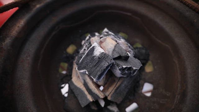 Fresh saury ready for grilling beside a charcoal grill