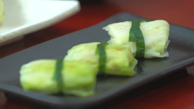 Freshly prepared cabbage rolls on a black plate