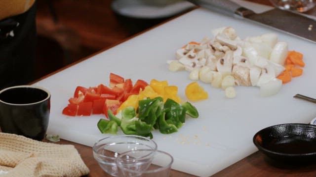 Preparing a stir-fry with bell peppers, mushrooms, and meat