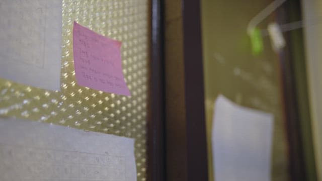 Sticky notes and papers attached to a glass window