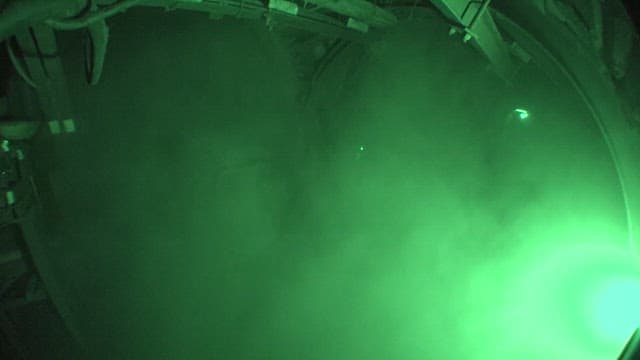 Inside a coal mine, brightly lit by green lights