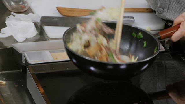 Cooking stir-fry vegetables and meat in a frying pan