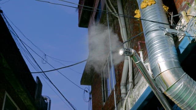 Steam venting from a pipe on a building