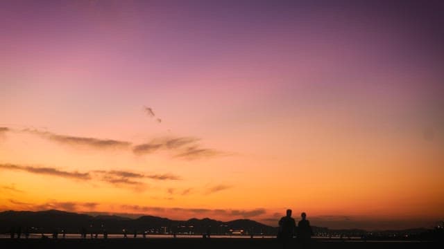 People Walking on the Beach Under a Beautiful Sky at sunset